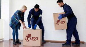 A crew of two movers in Richmond TX from Leo's Moving Services helping to move boxes in a residential setting